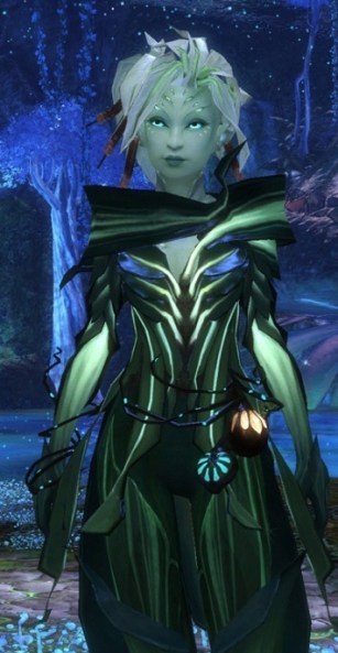 Green skinned, plant like woman from Guild Wars 2 wearing leafy clothing, with bedraggled, short white hair